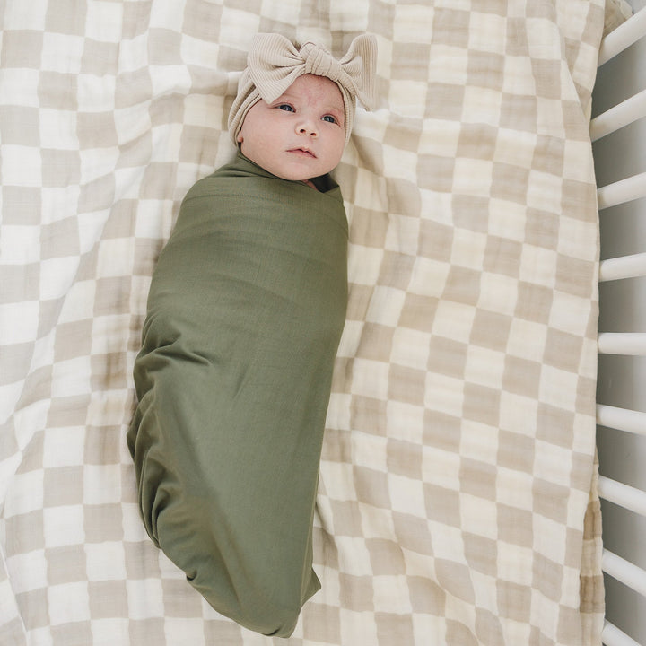 Breathable bamboo swaddle blanket for newborns, the Olive Bamboo Stretch Swaddle shown in a flat lay to highlight the fabric.