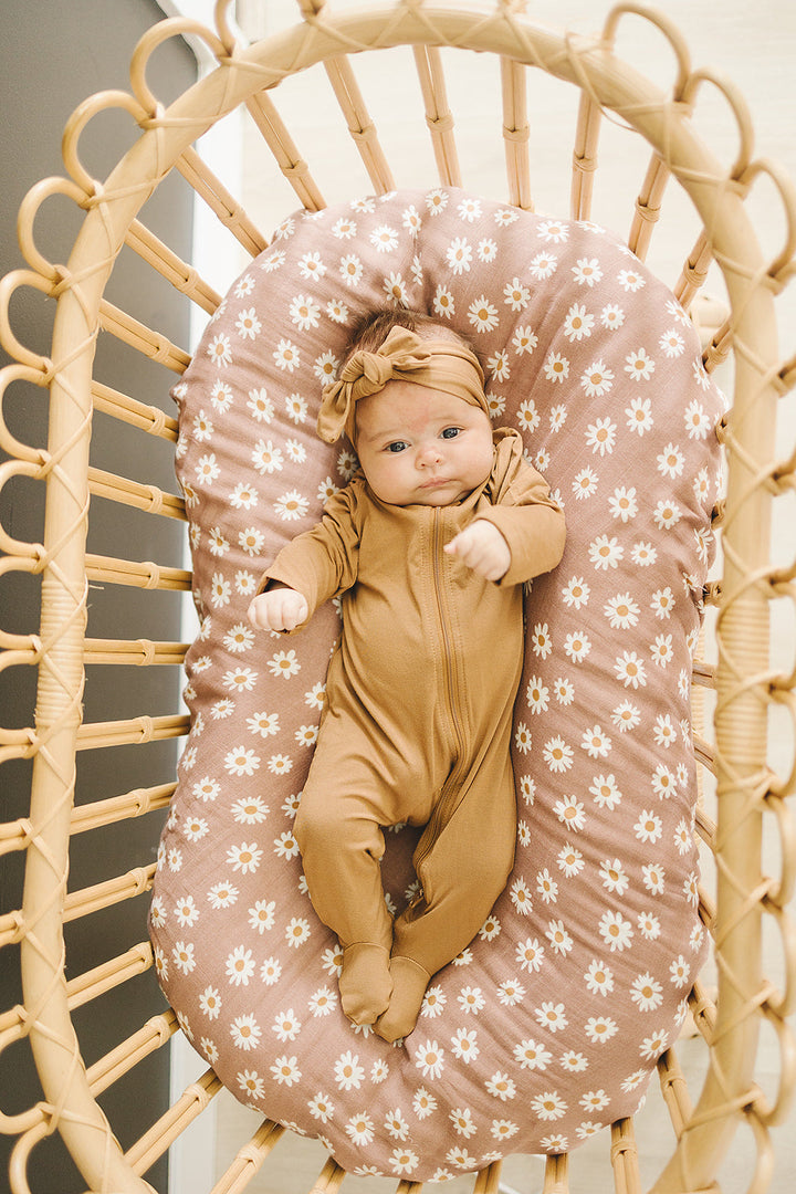 Styled flat lay of the Mustard Bamboo Footed Zipper, a popular zipper baby pajama from Mebie Baby