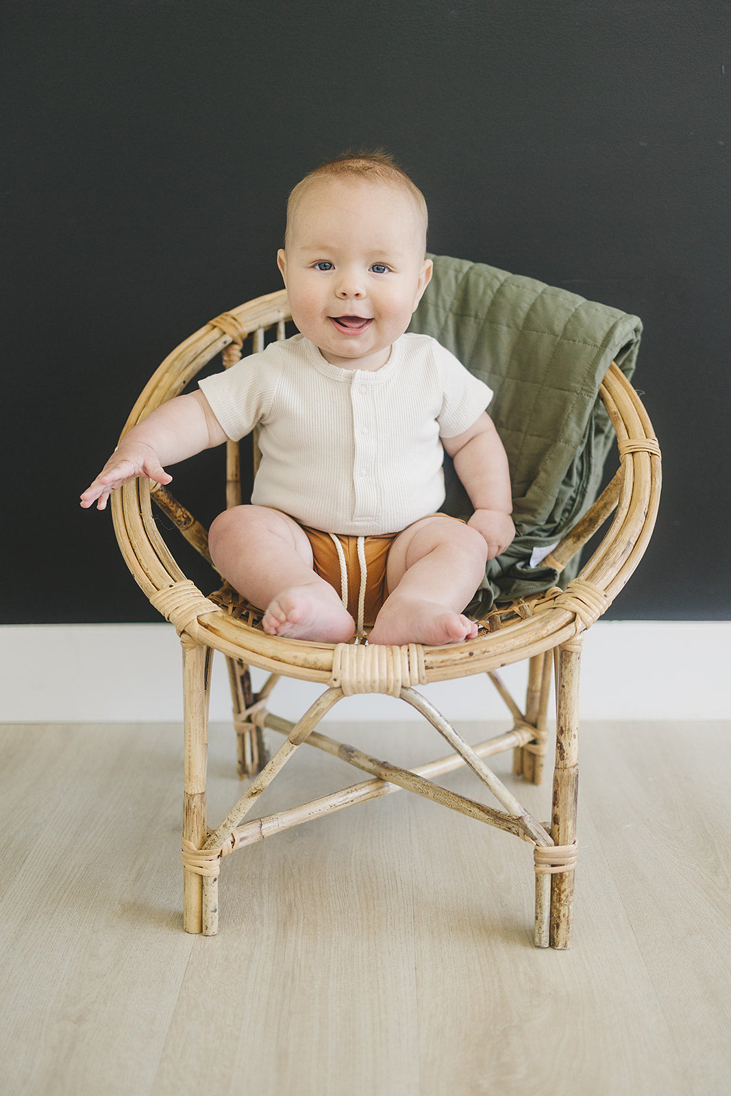 Laid flat to show the ribbed fabric, the Vanilla Organic Cotton Ribbed Snap Bodysuit from Mebie Baby.