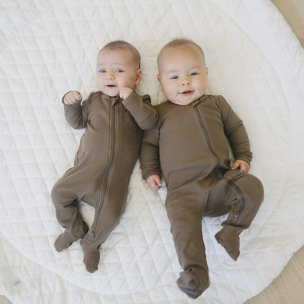 Babies wearing the new organic cotton ribbed zipper onesie 