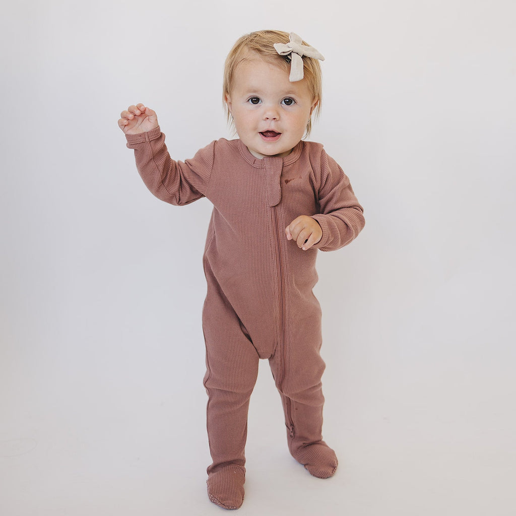 Baby wearing the dusty rose organic cotton one piece with footies