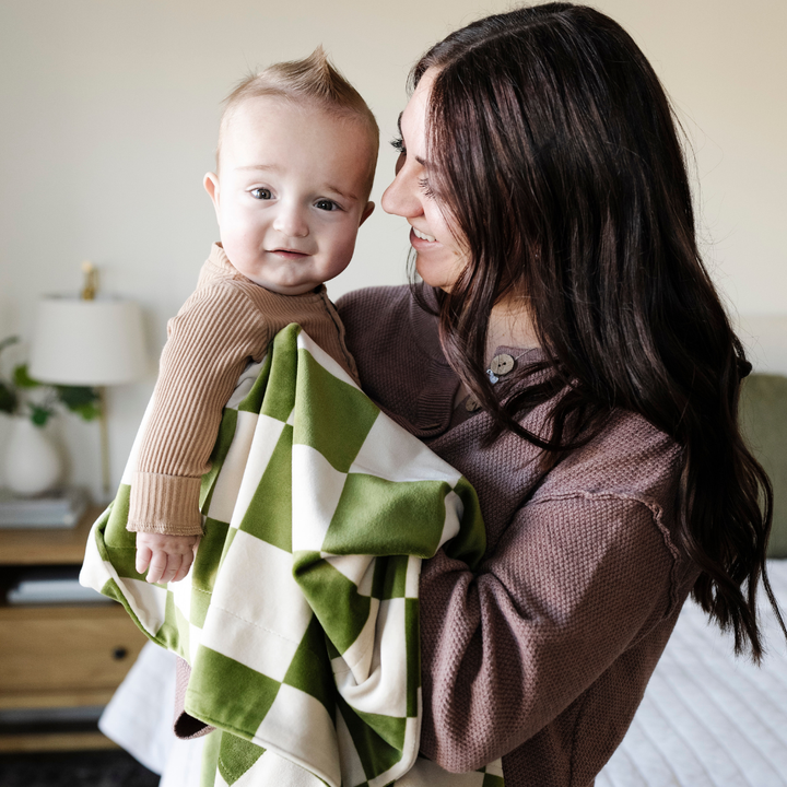 Infused with timeless style, the Saranoni Minky Stretch Receiving Blanket in Olive Checkered is a must-have baby receiving blanket.