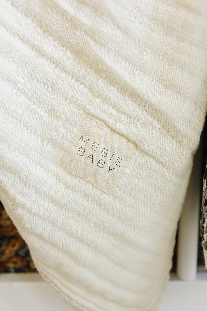 Perfect for cuddle moments, this Cream Lace Muslin Quilt from Mebie Baby doubles as a muslin baby blanket.