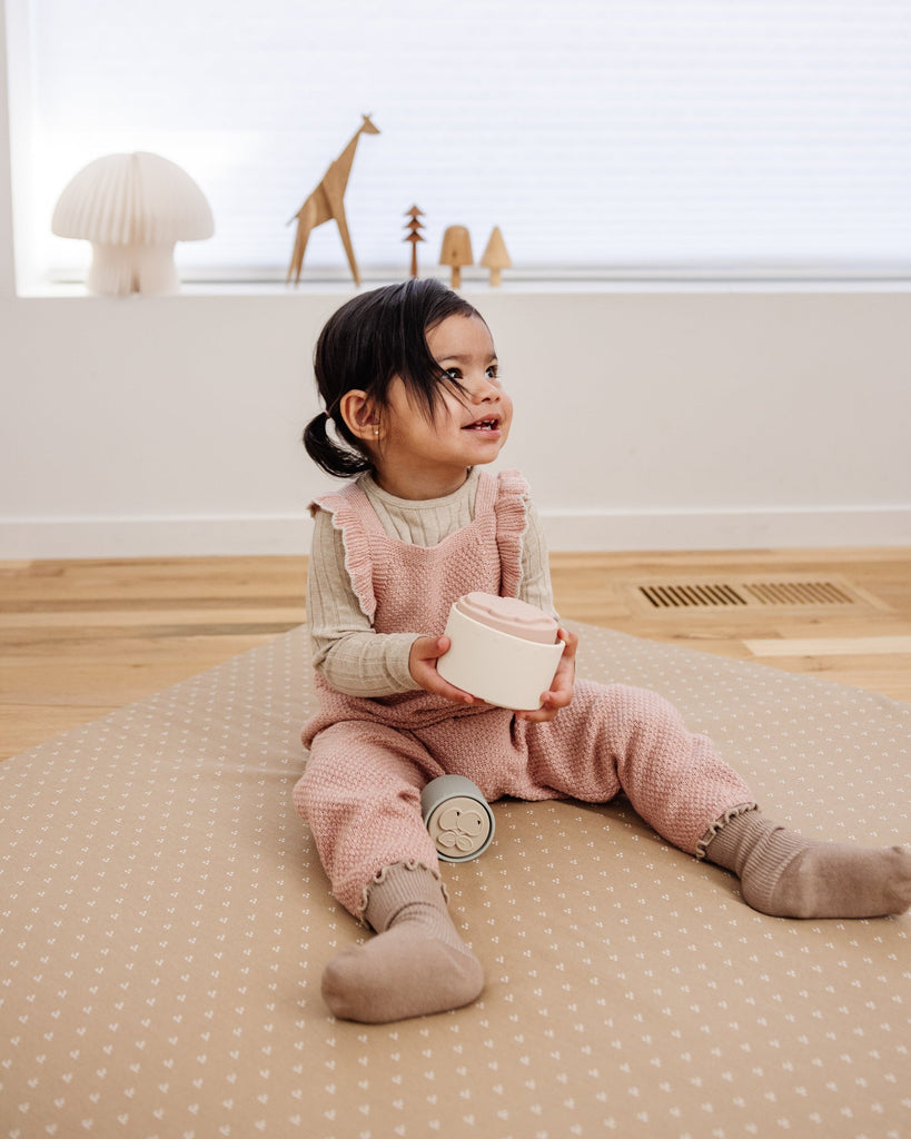 Little girl playing with toys on the machine washable Piccalio play mat.