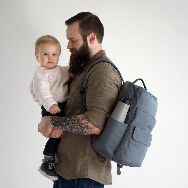 Little Unicorn Red Rovr Roo Backpack - Charcoal pictured on surface, stylish and lightweight kids travel backpack.