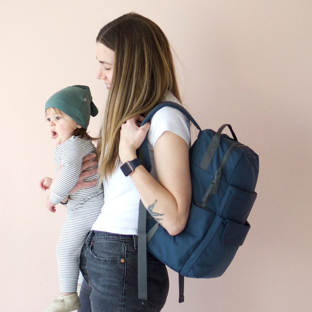 Lifestyle image of the Little Unicorn Red Rovr Roo Backpack in Navy, perfect for weekend outings and kids travel backpack needs.
