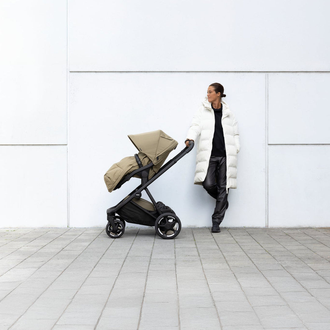 Lifestyle image of the Thule Charm Stroller with Thule Elements footmuff | stroller w/ newborn insert