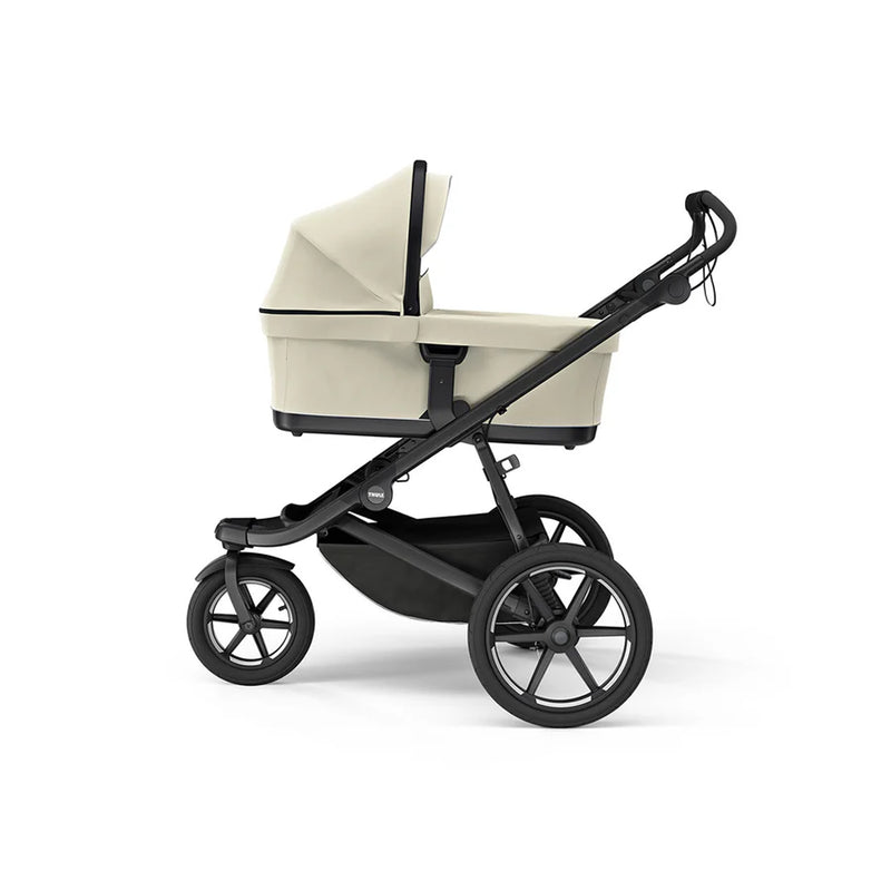 Soft beige Thule bassinet, offering a cozy ride for your baby in style.