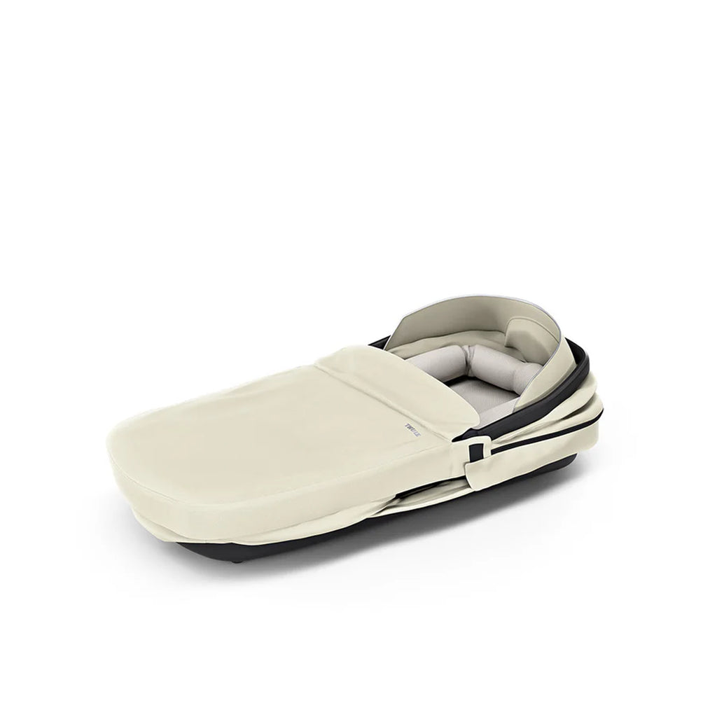 Soft beige Thule infant bassinet, perfect for easy stroller attachment.