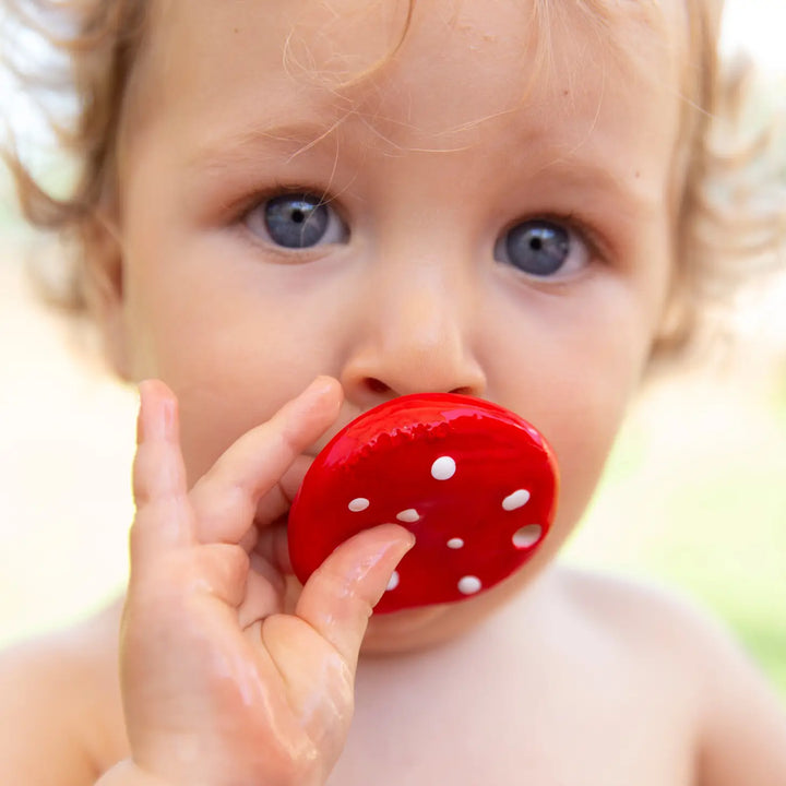 Baby chewing on Oli & Carol natural rubber mushroom teething toy
