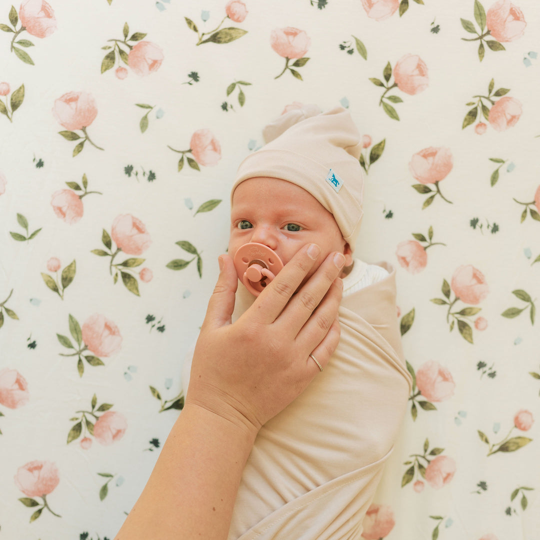 The Little Unicorn Stretch Knit Crib Sheet - Watercolor Rose folded to show pattern detail, crafted from premium organic crib sheets.