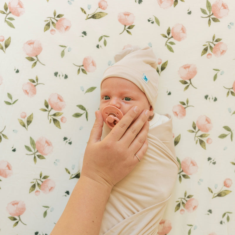 The Little Unicorn Stretch Knit Crib Sheet - Watercolor Rose folded to show pattern detail, crafted from premium organic crib sheets.