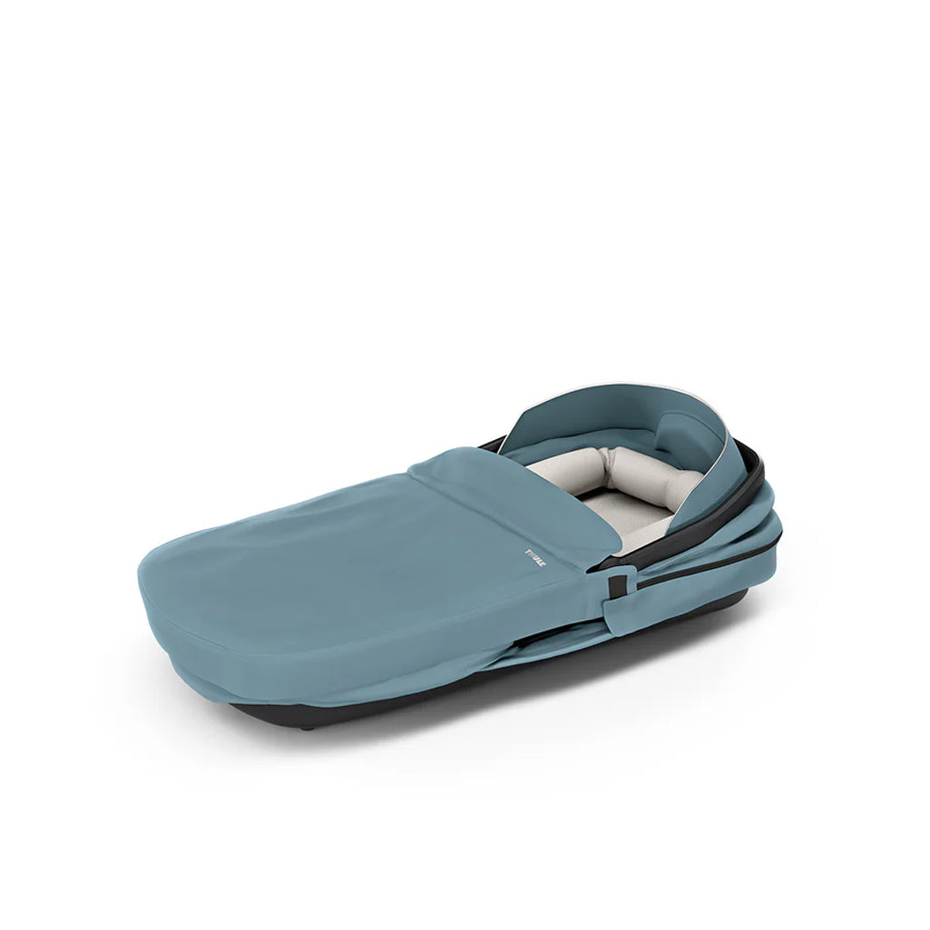 Midnight blue Thule baby bassinet, perfect for stroller rides with a modern touch.