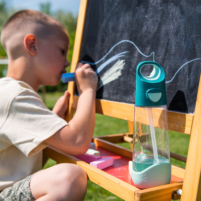 boy drawing on chalkboard with tritant large water drinking bottle bbox