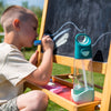 boy drawing on chalkboard with tritan water bottle by bbox nearby