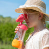 girl drinking from strawberry shake tritan bottle in meadow