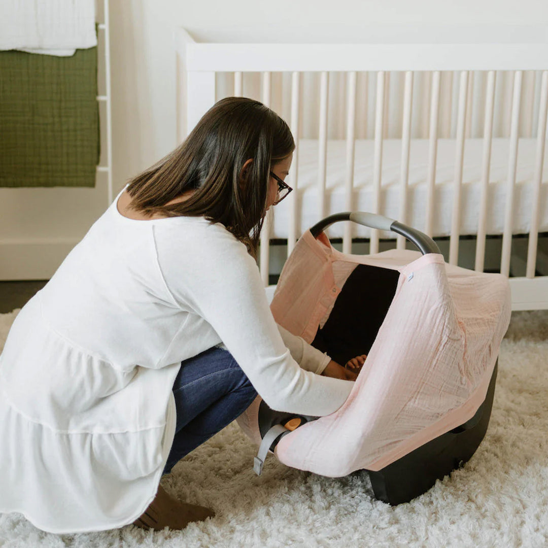 Charming blush tone featured on the Little Unicorn Cotton Muslin Car Seat Canopy - Light Pink, a must-have car seat accessory for parents.
