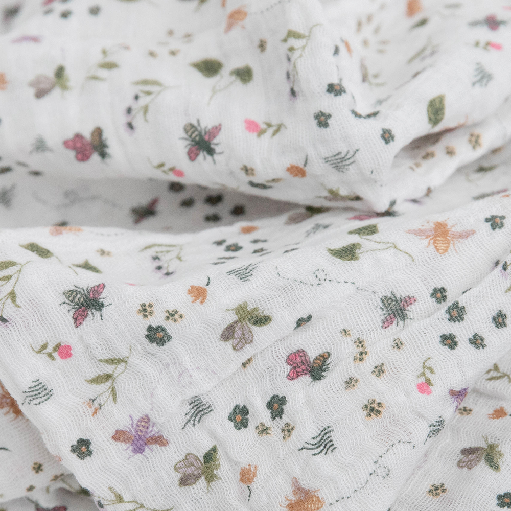 Cozy Little Unicorn Garden Bees muslin swaddle blanket, perfect for gentle swaddling.