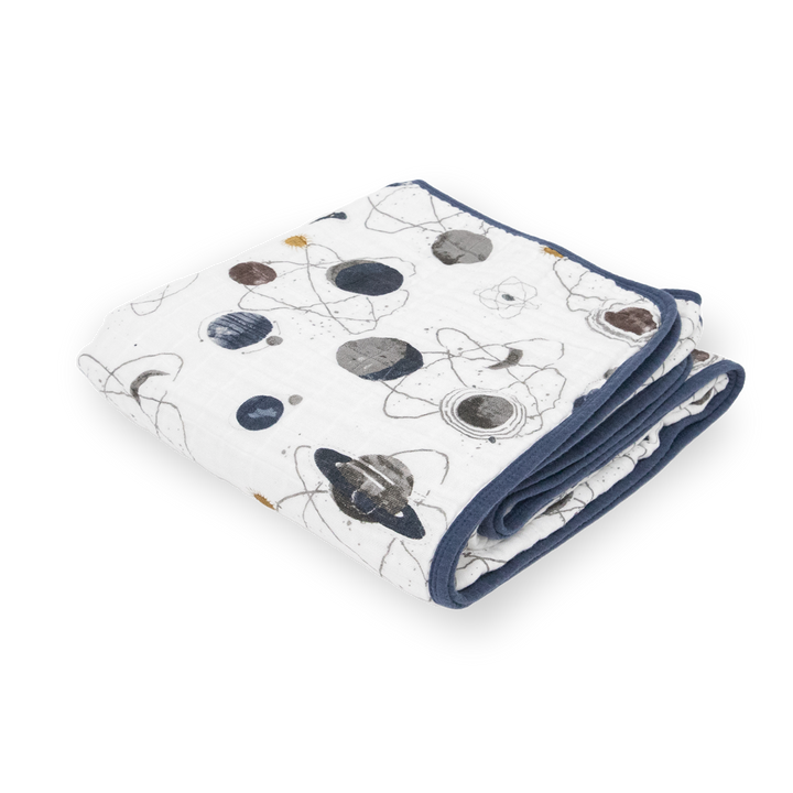 Little Unicorn Original Cotton Muslin Quilt - Planetary neatly folded, a soft and cozy baby blanket featuring charming space designs.