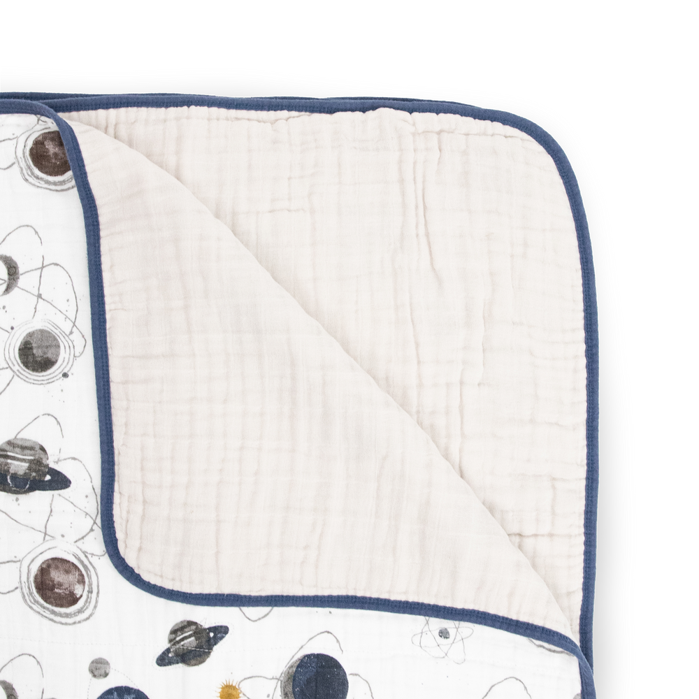 The Little Unicorn Original Cotton Muslin Quilt - Planetary shown open, a lightweight muslin blanket perfect for snuggles and naps.