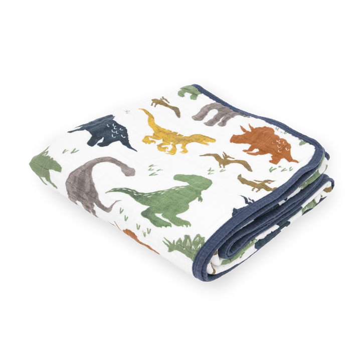 Little Unicorn Original Cotton Muslin Quilt - Dino Friends neatly folded, a soft and cozy baby blanket featuring playful dinosaur prints.