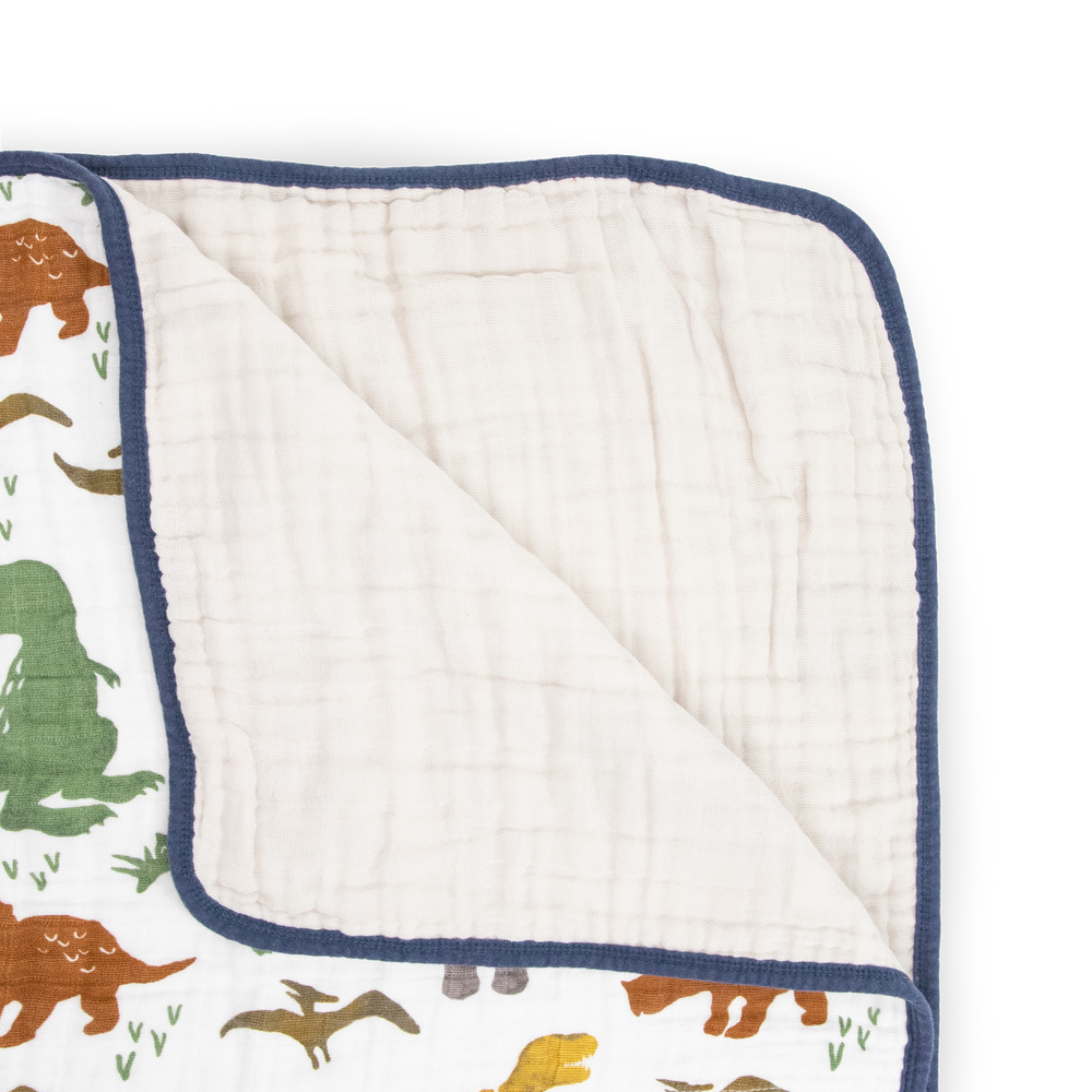 The Little Unicorn Original Cotton Muslin Quilt - Dino Friends displayed open, a breathable muslin blanket designed for everyday snuggles.