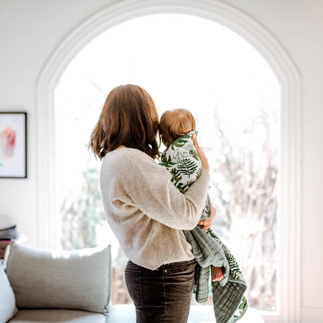 Soft and airy Little Unicorn Original Cotton Muslin Quilt - Tropical Leaf shown styled, part of the brand’s elegant baby quilts collection.