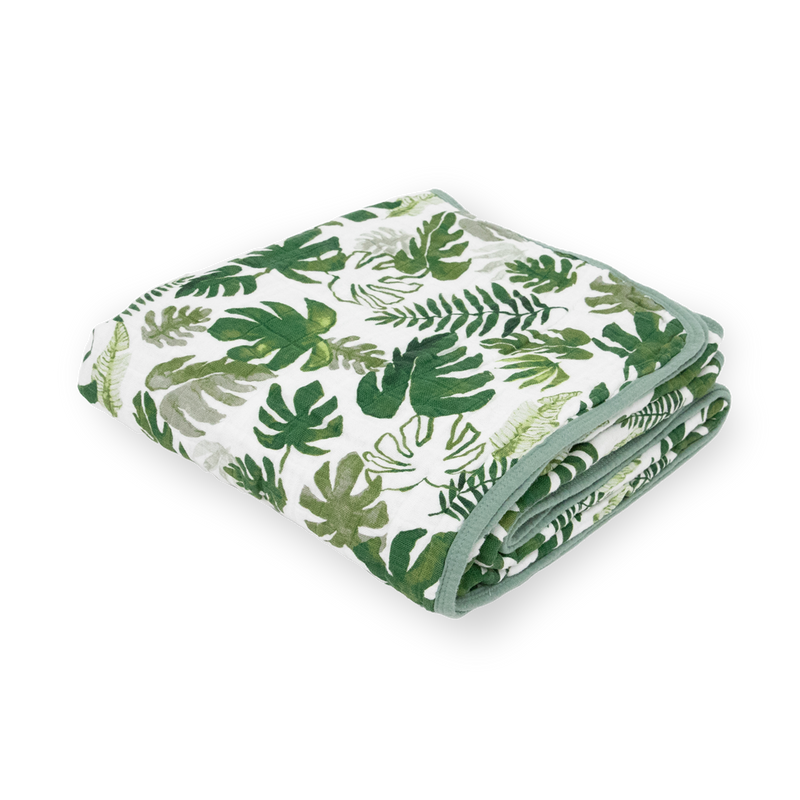Little Unicorn Original Cotton Muslin Quilt - Tropical Leaf neatly folded, a soft baby blanket with lush tropical-inspired patterns.