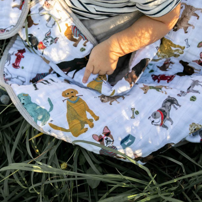 Little Unicorn Original Cotton Muslin Quilt - Woof draped on a chair, a fun and adorable baby quilt for little animal lovers.