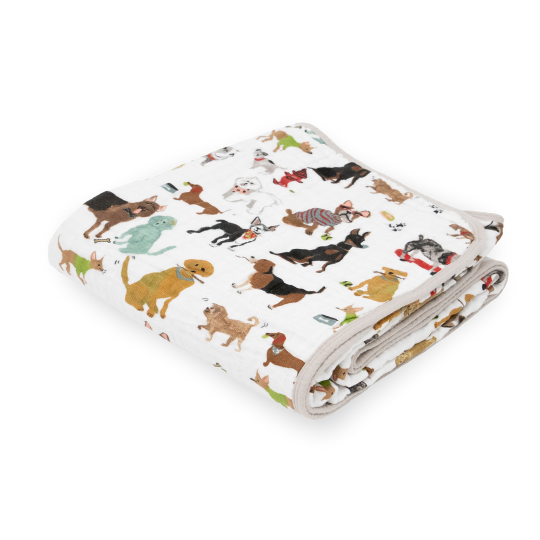 Little Unicorn Original Cotton Muslin Quilt - Woof neatly folded, a cozy baby blanket with playful dog-themed prints.