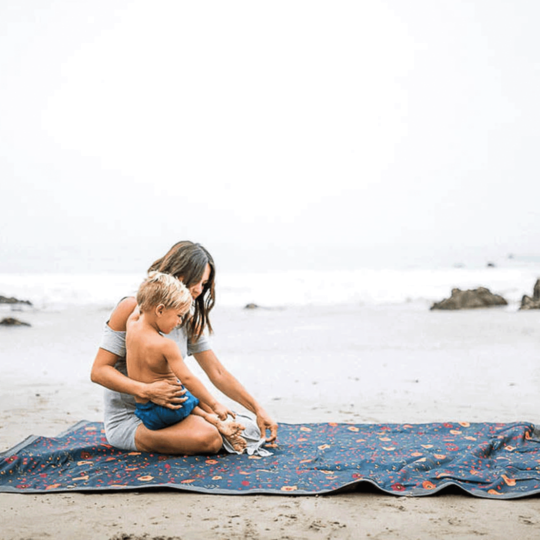 Animated demo of Little Unicorn Midnight Poppy outdoor blanket folding, convenient waterproof blanket outdoor for storage