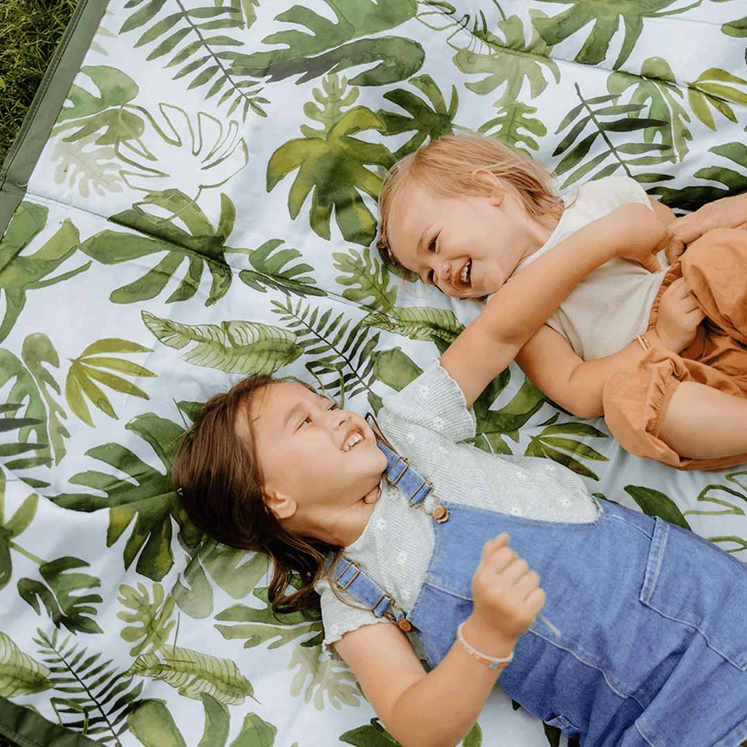 Picnic-ready Tropical Leaf Outdoor Blanket by Little Unicorn, compact outdoor blankets perfect for family or camping trips.