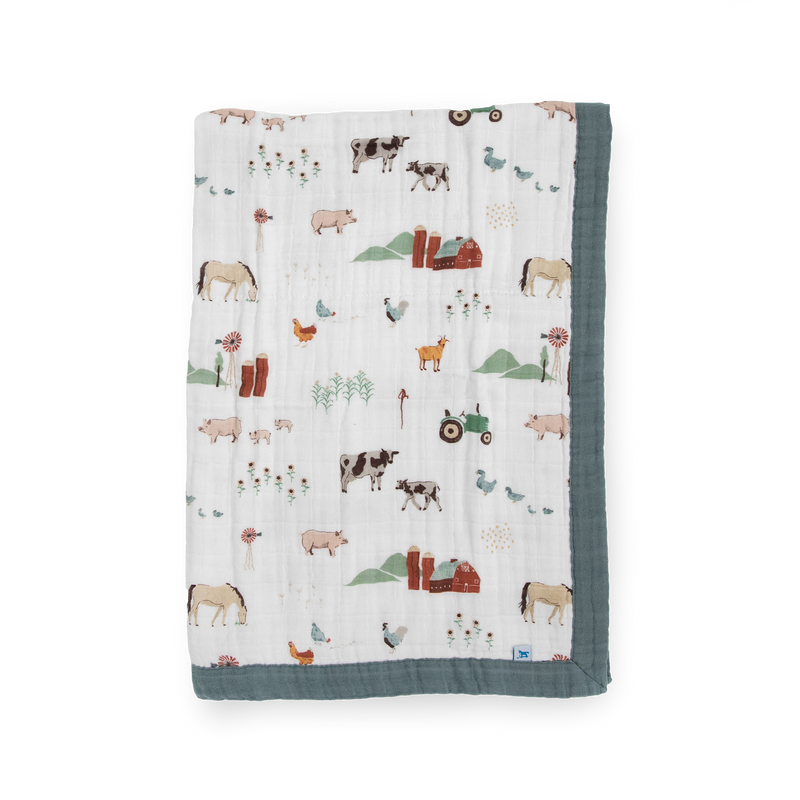 Little Unicorn Cotton Muslin Baby Quilt - Farmyard shown in a playful farm print, perfect for cozying up with a soft baby blanket.