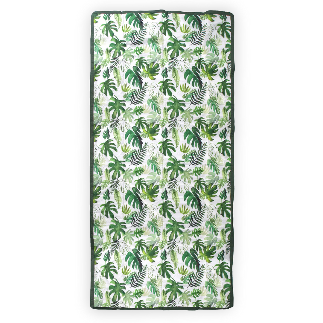Little Unicorn’s Tropical Leaf waterproof outdoor blanket, lightweight and durable for outdoor adventures.