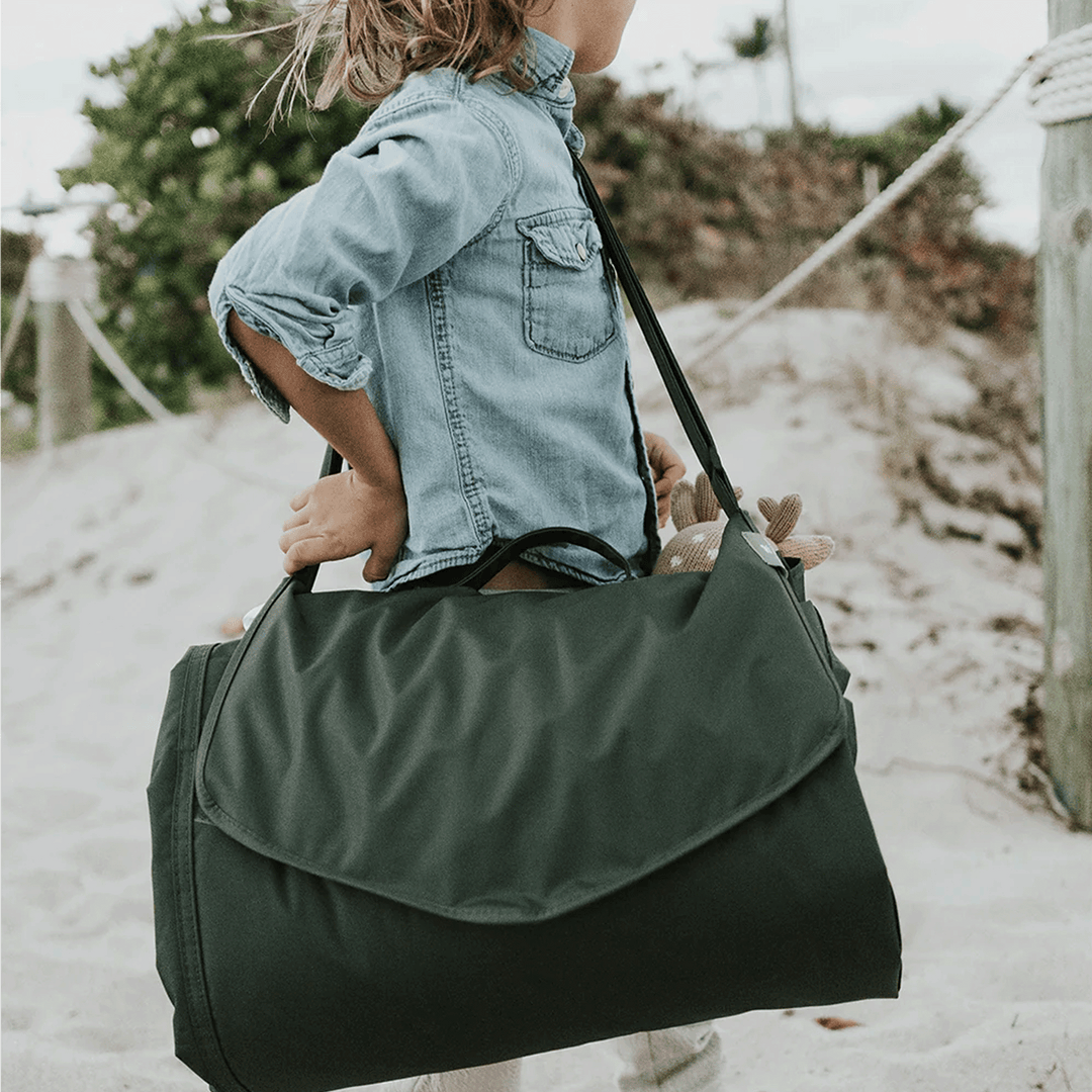 Little Unicorn Outdoor Blanket - Tropical Leaf displayed on lawn, lightweight outdoor blankets for travel and leisure.