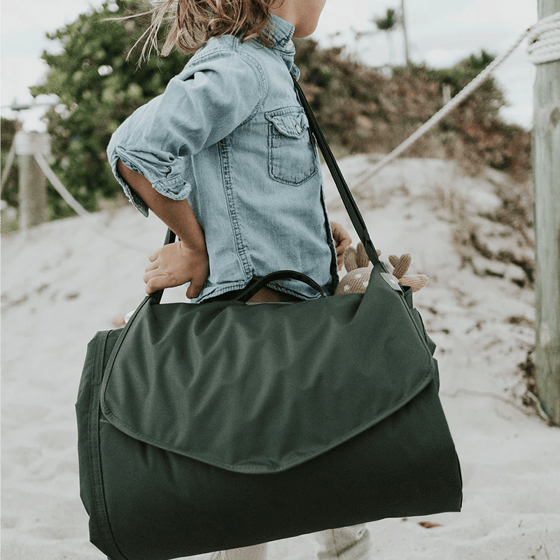 Little Unicorn Outdoor Blanket - Tropical Leaf displayed on lawn, lightweight outdoor blankets for travel and leisure.