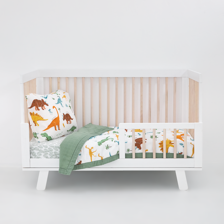 The Little Unicorn Cotton Muslin Toddler Comforter - Dino Names is a muslin swaddle for gentle bedtime comfort.