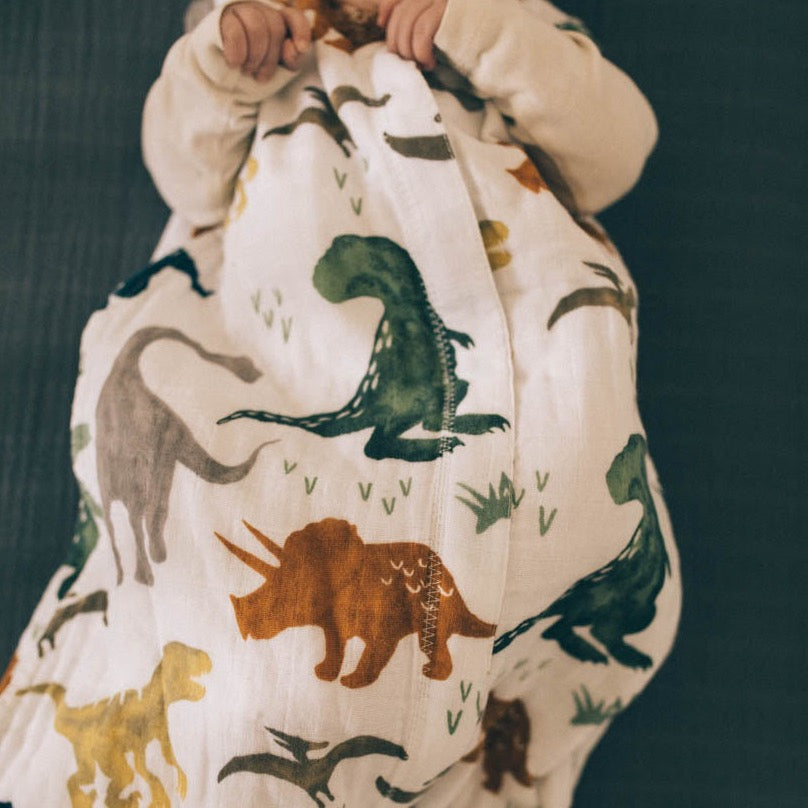 The Little Unicorn Cotton Muslin Sleep Bag - Dino Friends provides a snug sleep bag baby for toddlers.