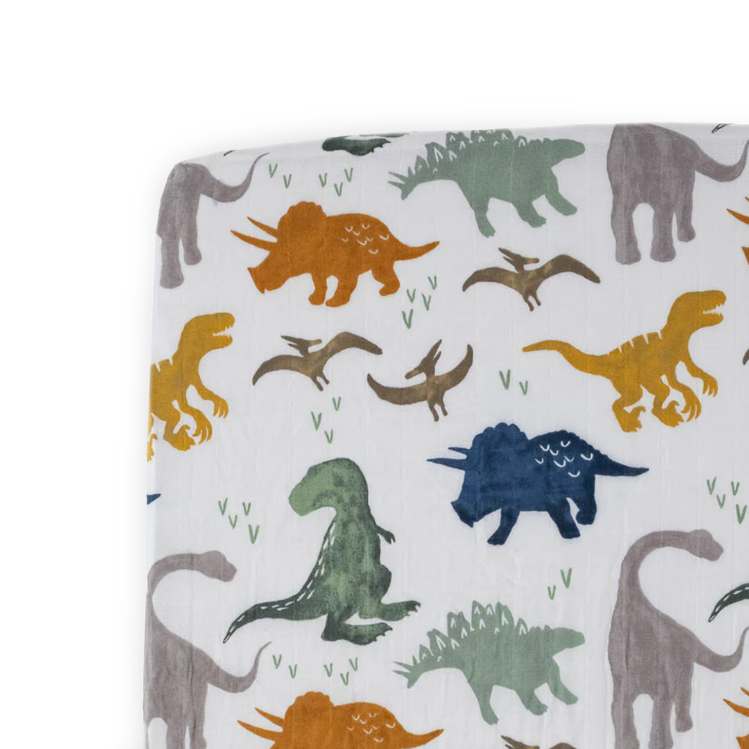 Little Unicorn Cotton Muslin Crib Sheet - Dino Friends brings playful dinosaurs to life with soft and breathable muslin crib sheets.