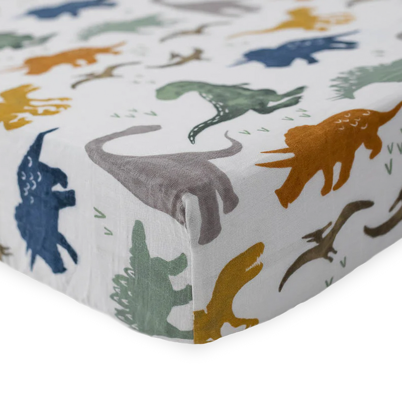Fun and colorful Little Unicorn Cotton Muslin Crib Sheet - Dino Friends, crafted from premium organic cotton crib sheets for cozy sleep.