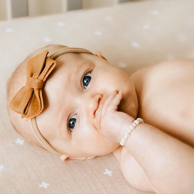 Little Unicorn Cotton Muslin Crib Sheet - Taupe Cross close-up view, lightweight texture perfect for crib mattress sheets.