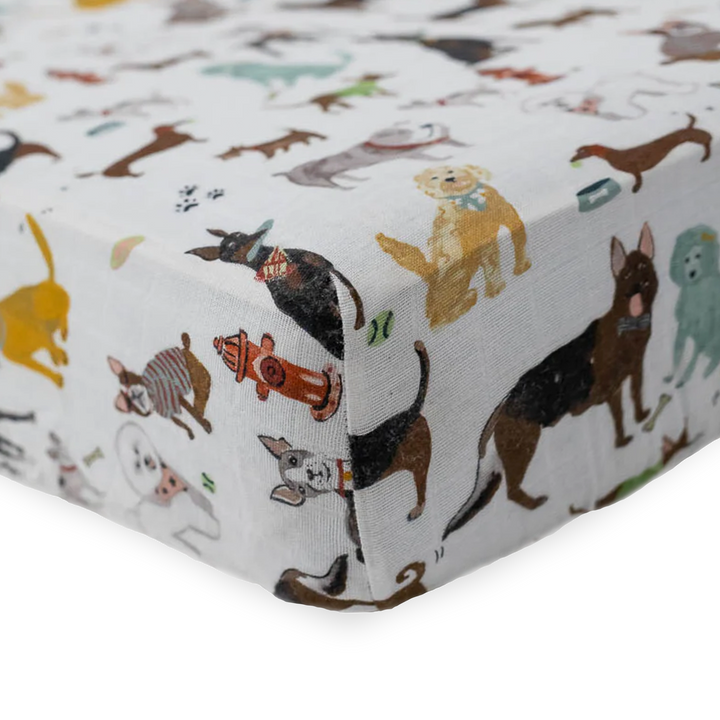 Close-up of Little Unicorn Cotton Muslin Crib Sheet - Woof showing playful dog print, adorable baby crib sheets for nurseries.