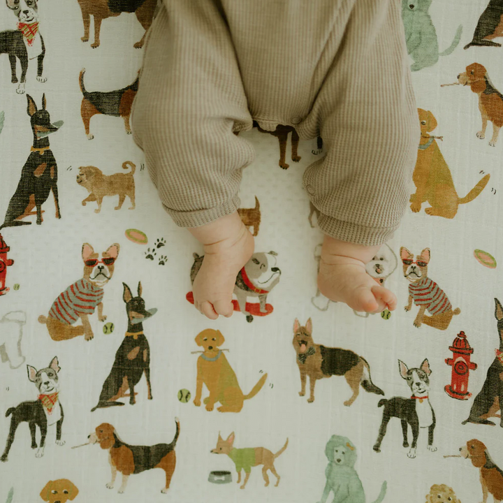 Detailed view of Little Unicorn Cotton Muslin Crib Sheet - Woof, made with premium fabric for organic crib bed sheets.