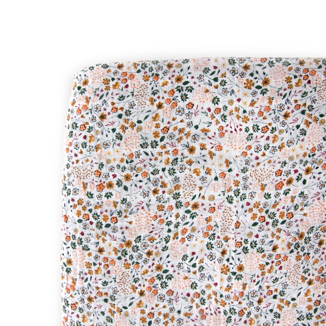 Little Unicorn Cotton Muslin Crib Sheet - Pressed Petals displayed neatly folded, soft floral muslin crib sheets for cozy sleep.