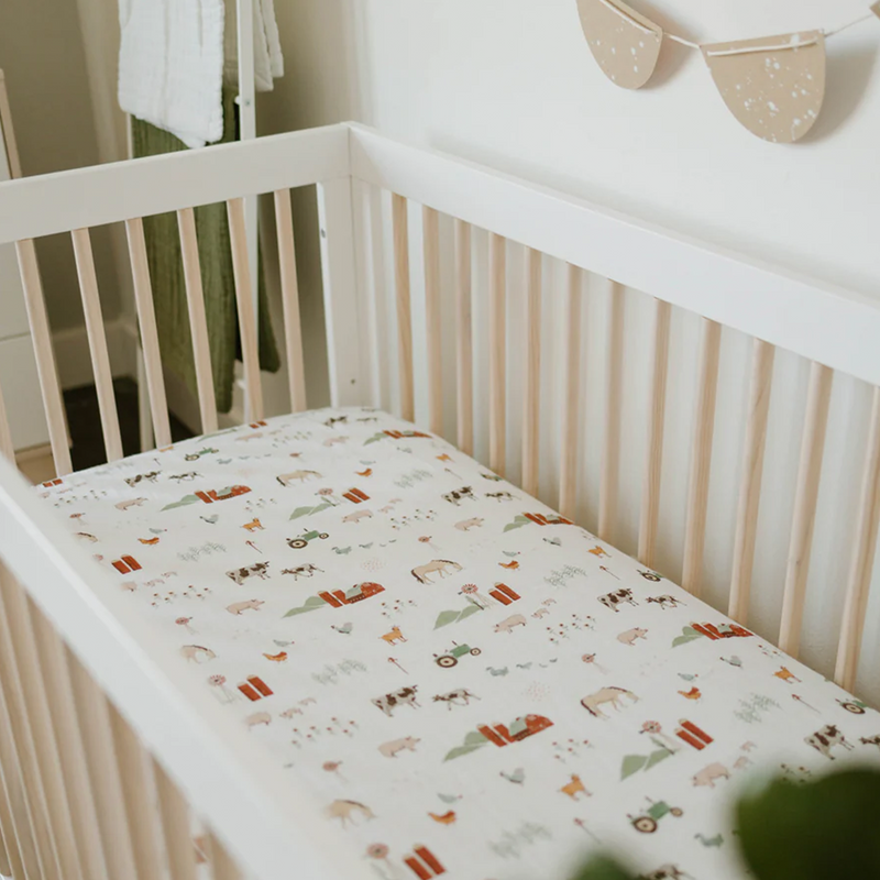 Little Unicorn Cotton Muslin Crib Sheet - Farmyard shown on mattress, durable and comfy crib bed sheets for everyday use.