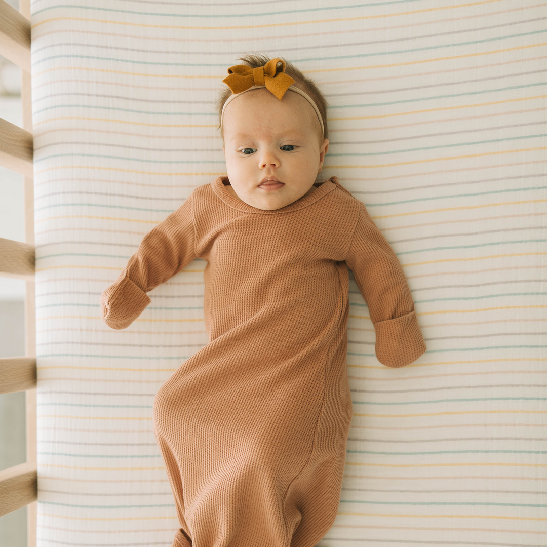 Little Unicorn Cotton Muslin Crib Sheet - Unicorn Stripe styled on mattress, lightweight muslin for the best crib sheets.