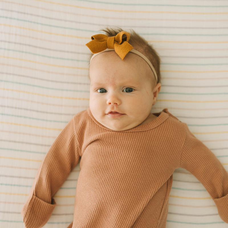 Colorful striped Little Unicorn Cotton Muslin Crib Sheet - Unicorn Stripe, premium organic cotton crib sheets for modern nurseries.