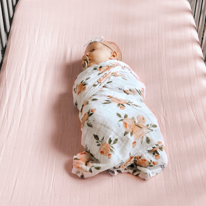Little Unicorn Light Pink Cotton Muslin Crib Sheet styled on crib, one of the best crib sheets for newborns
