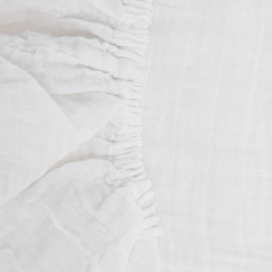 Little Unicorn White Organic Cotton Muslin Crib Sheet styled on crib, one of the best crib sheets for newborns