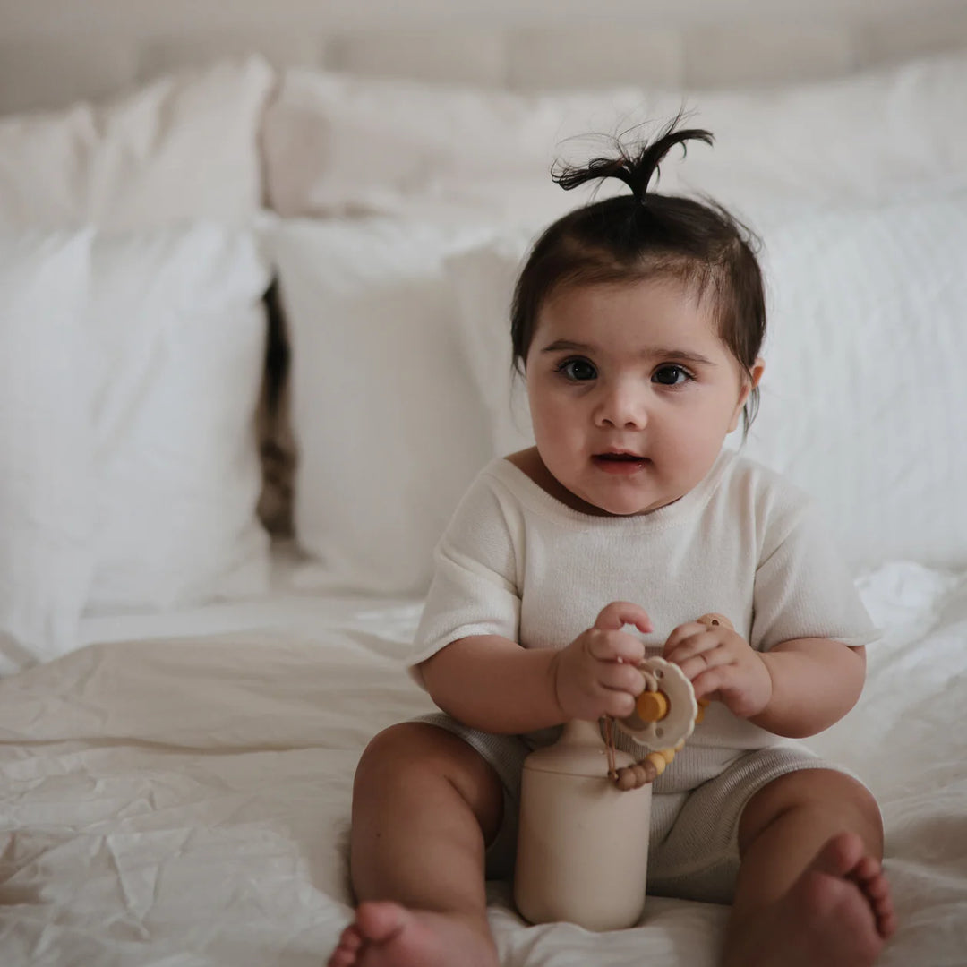 Toddler with FRIGG Snowflake Dream silicone pacifier - lifestyle photo showing pacifier in everyday use